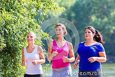 Group of women running at lakeside jogging Stock Photo