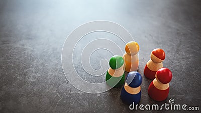 Group of wooden figurines in different colors standing in a circle Stock Photo