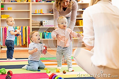Group of workers with babies in nursery Stock Photo