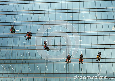 Group of workers cleaning windows service on high rise building. window washers industrial climbers Editorial Stock Photo