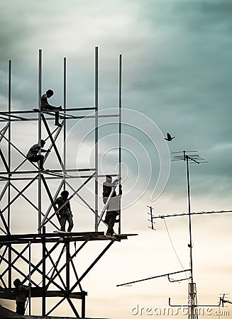 Group of workers are climbing poles to install billboards Editorial Stock Photo