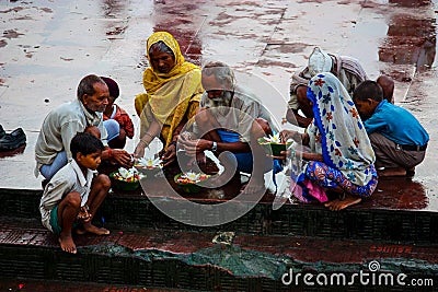 Haridwar, India - August 20, 2009: group of worshipers preparing flowers to leave in the waters of the Ganges at Haridwar, Editorial Stock Photo