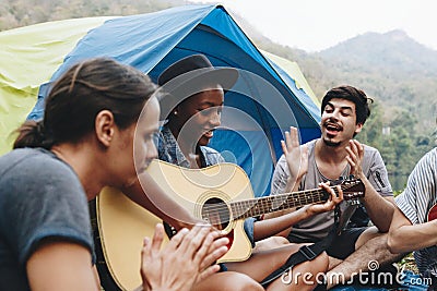 Group of young adult friends in camp site playing guitar Stock Photo