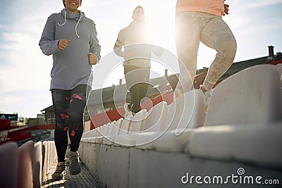 Group of young adults running between rows of seats at the stadium Stock Photo