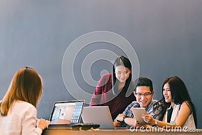 Group of young Asian business colleagues in team casual discussion, startup project business meeting or happy teamwork brainstorm Stock Photo