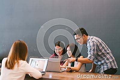 Group of young Asian business colleagues in team casual discussion, startup project business meeting or happy teamwork brainstorm Stock Photo