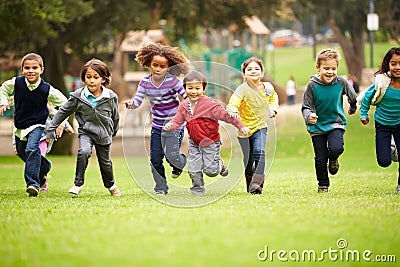 Group Of Young Children Running Towards Camera In Park Stock Photo