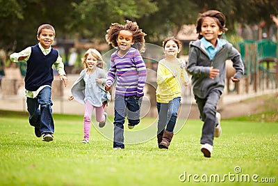 Group Of Young Children Running Towards Camera In Park Stock Photo