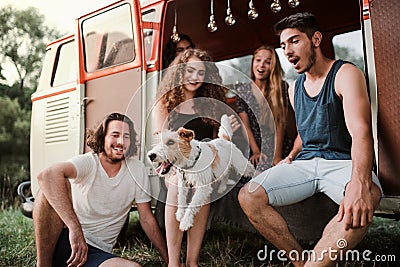 A group of young friends with a dog on a roadtrip through countryside. Stock Photo