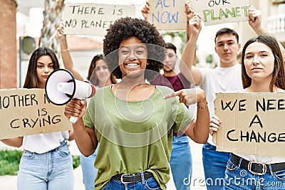 Group of young friends protesting and giving slogans at the street pointing finger to one self smiling happy and proud Stock Photo