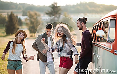 A group of young friends on a roadtrip through countryside, dancing. Stock Photo