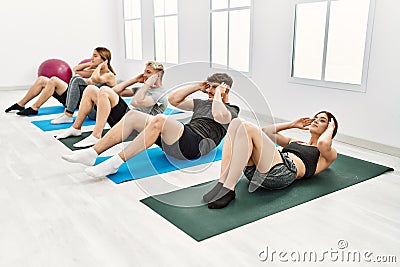 Group of young hispanic people concentrate training abdominal exercise at sport center Stock Photo