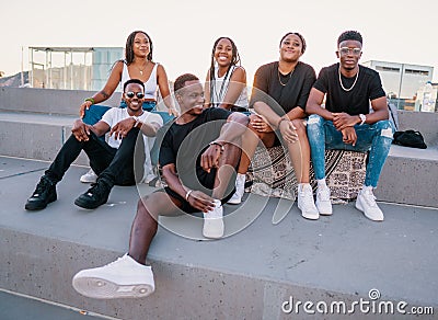 Group of young modern african black friends happily sitting together Stock Photo