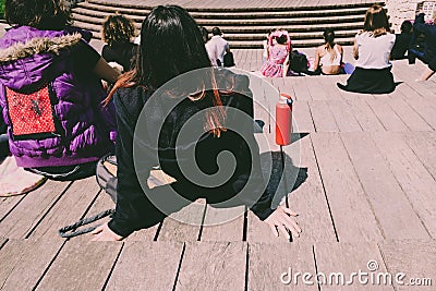 Group of young people attend an outdoor show, seen from behind unrecognizable Editorial Stock Photo