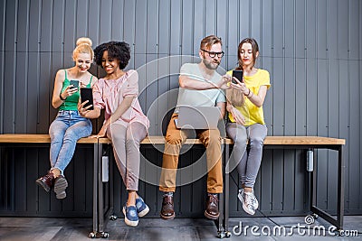 Group of young people with gadgets indoors Stock Photo