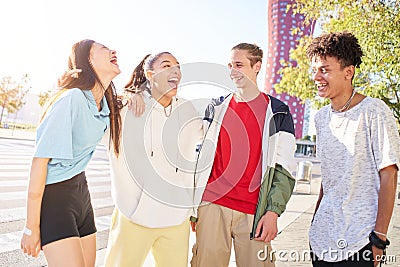 Group of young people having fun together outdoors. Portrait of multiethnic students laughing at the city. Stock Photo