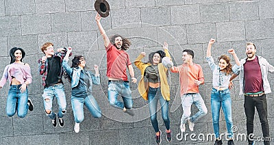 Group of young people jumping together outdoor - Happy millennial friends celebrating success in college Stock Photo