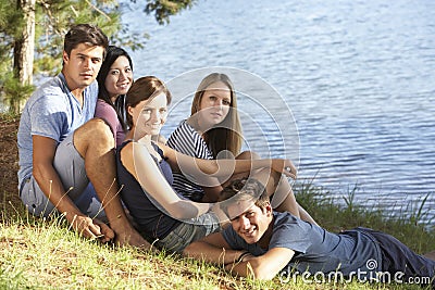 Group Of Young People Relaxing At Shore Of Lake Stock Photo