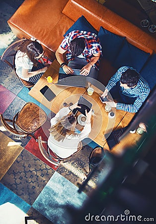 Group of young people sitting at a cafe, with mobiles and tablets Stock Photo