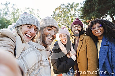 Group of young people smiling and having fun taking selfie portrait. Five multiracial happy friends looking at camera Stock Photo