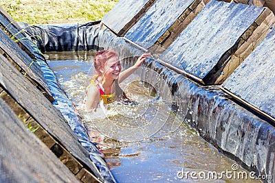 a group of young sport girl overcome the obstacles of the race of heroes competition. Text in Russian: Race of Heroes Editorial Stock Photo