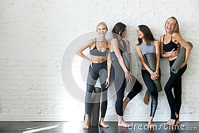 Group of young sporty girls with yoga mats, copyspace Stock Photo