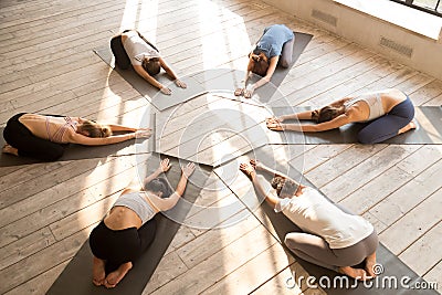 Group of young sporty people practicing yoga lesson, Balasana po Stock Photo