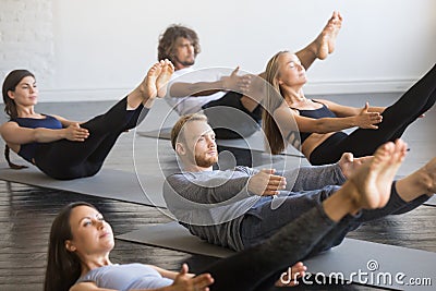 Group of young sporty people in Paripurna Navasana pose Stock Photo