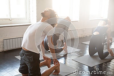 Group of young sporty people in Ustrasana pose Stock Photo