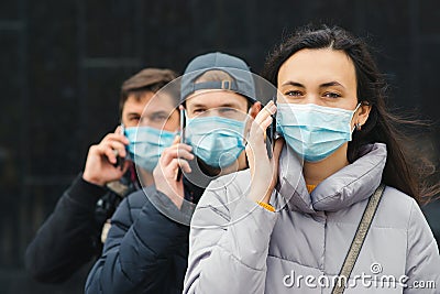 Group of young volunteers wearing face masks with mobile phones. Volunteers are ready to help. Call to volunteers Stock Photo