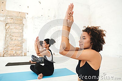 Group of young women doing yoga stretching exercises Stock Photo