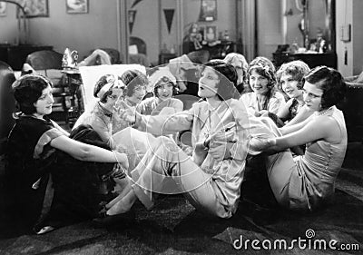 Group of young women sitting on the floor of a living room talking Stock Photo