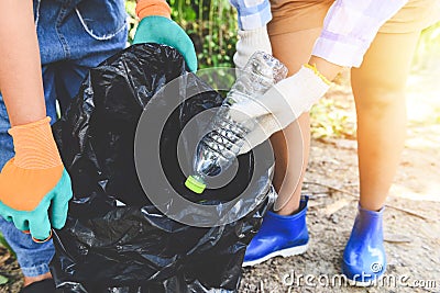 Group of young women volunteers helping to keep nature clean and picking up the garbage plastic bottle from park - Recycling and Stock Photo