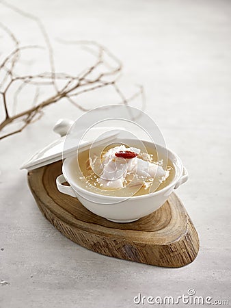 Grouper Fillet in Winter Melon and Conpoy Soup Served in a bowl isolated on wooden board side view on grey background Stock Photo