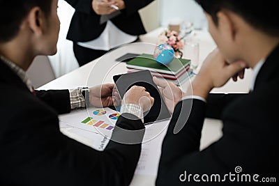 Groups of Asian businessmen are meeting. By using a digital tab Stock Photo