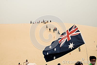 Tourists sliding sand board down the sand dunes in Port Stephen, Australia Editorial Stock Photo