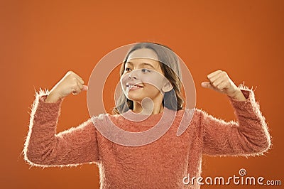 Grow up strong and confident. feel power of herself. cheerful child orange backdrop. carefree childhood. healthy and Stock Photo