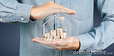 Growing coins house on stack coins in hand. Concept of Investment propert Stock Photo