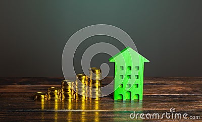 Growing stacks of coins and a green house. Investment in green technologies. Reducing impact on environment. Investments in Stock Photo