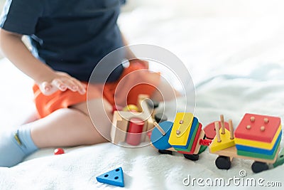 Growing up and kids leisure concept. A child playing with a colored wooden train. Kid builds constructor. Without face. Selective Stock Photo