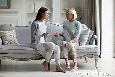 Grown up daughter and elderly mother having difference of opinion Stock Photo