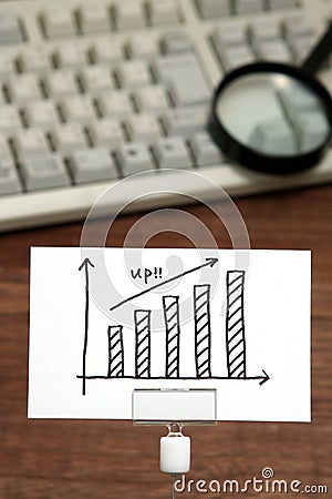 Growth Graph drawn on paper in front of computer keyboard and magnifying glass. Stock Photo