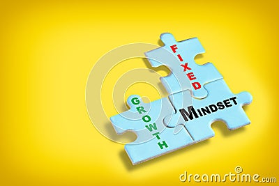 Growth mindset and fixed mindset written on blue puzzle jigsaw with shadow on yellow background Stock Photo