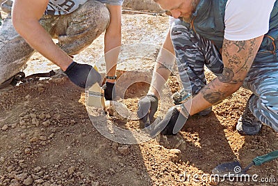 Groznii, Chechen Republic, Russia - Oct. 2018: Archaeological excavations. Two archaeologists with tools conducting research on hu Editorial Stock Photo