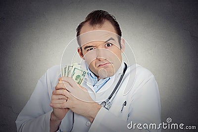 Grumpy greedy miserly health care professional holding money Stock Photo