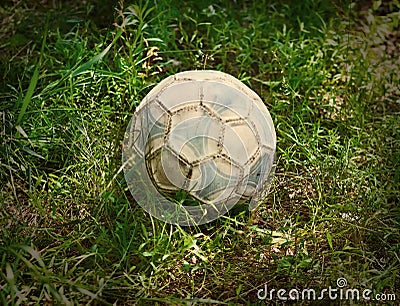 Grunge football or soccer ball on a green lawn Stock Photo