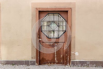 Grunge wooden door with hexagonal glass window Stock Photo