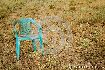 Grungy Retro Damaged Plastic Green Chair Abandoned in a Field Stock Photo