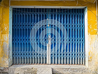 Grungy rusty blue and yellow metal gate Stock Photo