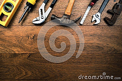 Grungy rusty craftsmen Tools like water scale, pliers, screwdriver, Hammer and tape measure on wooden planks with room for writing Stock Photo